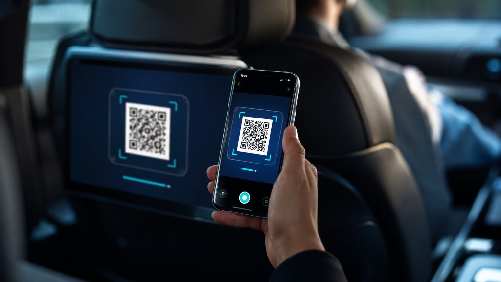 Passenger scanning a QR code on an in-ride headrest screen